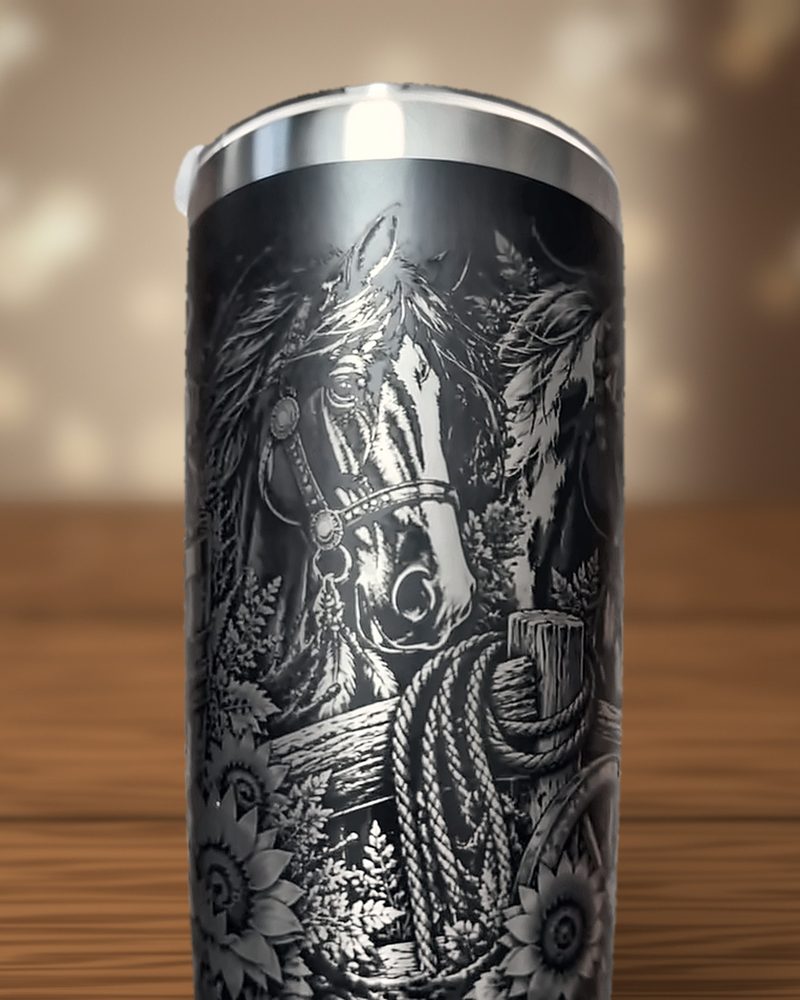 Black tumbler laser-engraved with a horse head, rope on a fence post and sunflowers