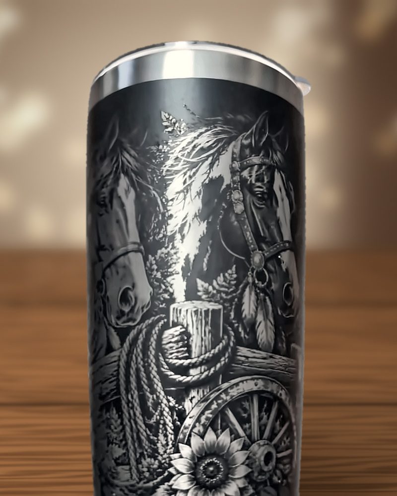Black tumbler laser-engraved with a coiled rope, fence post, wagon wheel and sunflower